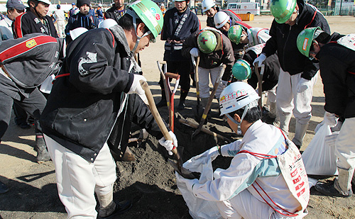堤防決壊等に備えて土のう作りを体験する参加者
