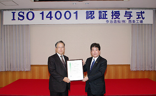 ISO14001認証証書を持ち、記念写真に収まる日本海事協会 冨士原副会長(左)と当社檜垣社長(右)