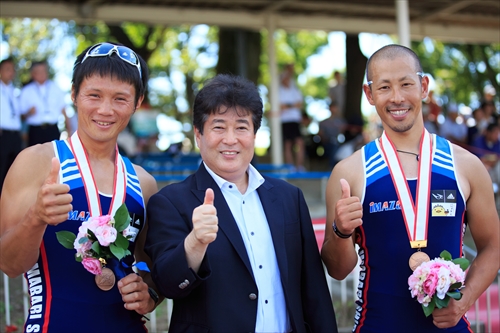 檜垣社長と共に表彰台の上で喜びを表す井出選手（右）と別府選手（左）