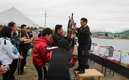 優勝チームへトロフィーに模した優勝ダリンを授与する瀬野今治工場長